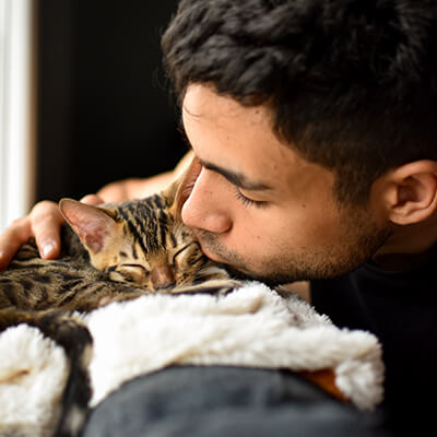 man kissing kitten